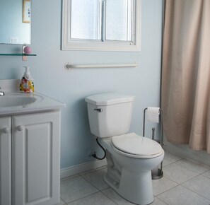 Un baño con inodoro, lavabo, espejo y ventana.