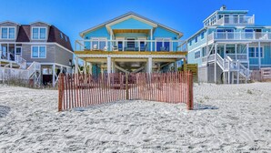 A beachfront property with a large house, a smaller house, and a building with a balcony. - Decked Out - Newly Renovated Four-Bedroom, Two-Bath Oceanfront Beach House (Garden City Beach)