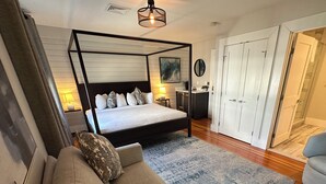 A bedroom with a four-poster bed, a sofa, a desk, and a wardrobe. - Spacious and modern 1 Bed/ 1 Bath / (Sleeps 4)  Dog friendly with parking on Historic Pelham St. (Newport)