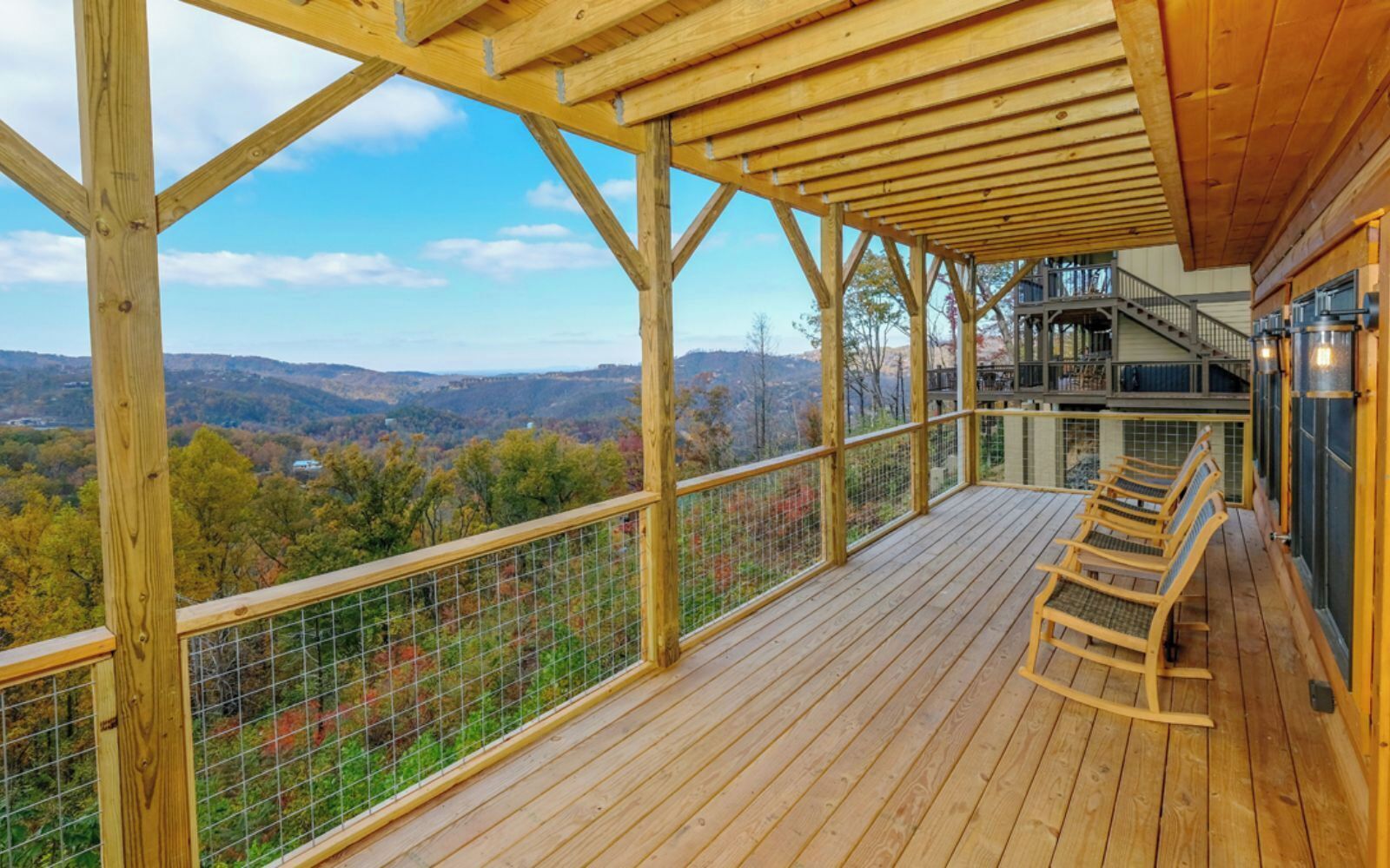 Une terrasse en bois offrant une vue sur un paysage montagneux.