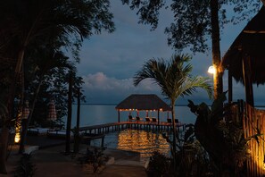 A wooden deck with lounge chairs, a thatched-roof structure, and a view of the water. - Mikasa Bacalar Hotel Boutique, Lagoon Front (Bacalar)