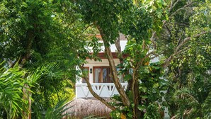 A tropical house surrounded by lush greenery, with a thatched roof and a white fence. - Mikasa Bacalar Hotel Boutique, Lagoon Front (Bacalar)