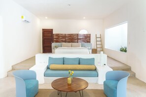 A modern living room with a sofa, two armchairs, a coffee table, and a staircase leading to a bedroom. - Mikasa Bacalar Hotel Boutique, Lagoon Front (Bacalar)