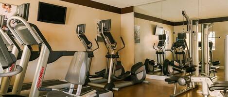 A gym with treadmills, elliptical machines, and weight equipment.