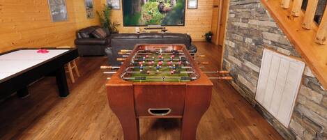 Ein gemütliches Zimmer mit Tischfußball, Billardtisch und einer komfortablen Sitzecke.
