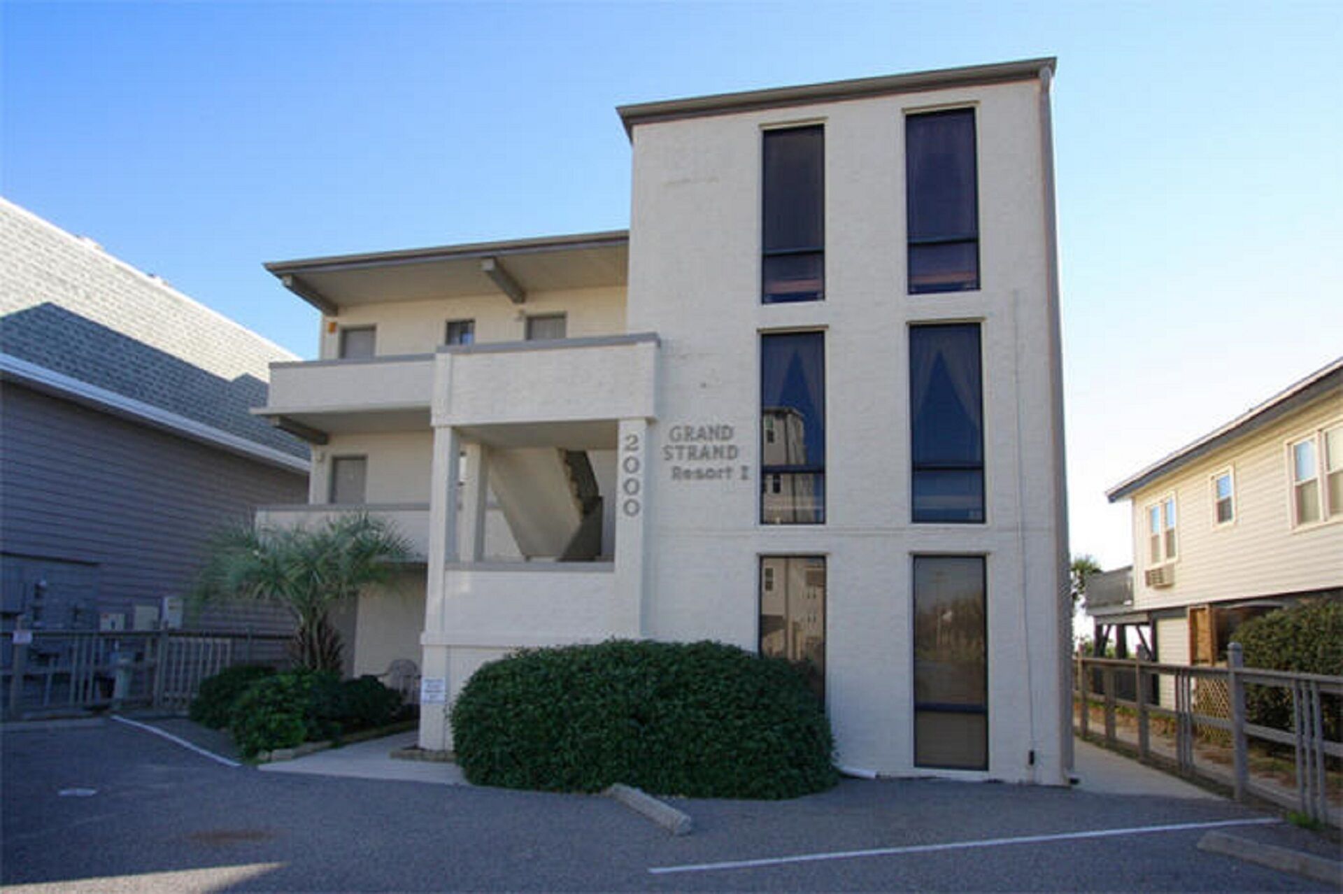 Een gebouw met twee verdiepingen, met een bord waarop 'Grand Strand Resort I' staat.