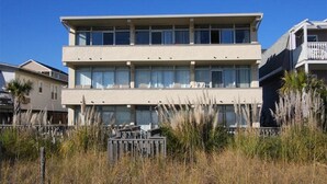 A two-story building with a flat roof and large windows.