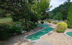 Experience the serene golfing atmosphere surrounded by lush greenery and rolling hills.