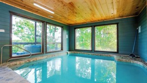 Ein Innenpool mit Holzbalkendecke und großen Fenstern.