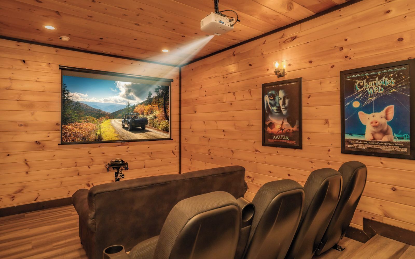 Une salle de cinéma chaleureuse avec des murs en bois, un grand écran et des sièges confortables.