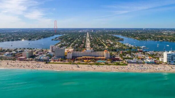 An aerial view of a coastal resort with a long central road, beachfront, and a large hotel with multiple buildings. - 4BR, Private Backyard Oasis/POOL & HotTub(Jacuzzy) (Hollywood)