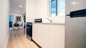 A modern kitchen with white cabinets, a built-in oven, and a window above the sink. - Modern Apart beside canal, near beach w/parking (Sunny Isles Beach)