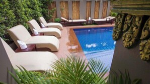 Ein Poolbereich mit Liegestühlen und einem gefliesten Pool.