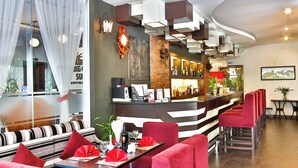 Ein modernes Restaurant mit Barbereich, roten Sitzmöglichkeiten und einer Theke mit Flaschendisplay.