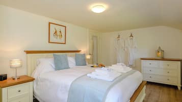 A bedroom with a bed, bedside tables, a nightstand, a dresser, a mirror, and a painting on the wall.