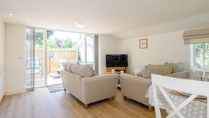 A spacious living room with a sofa set, a television, and a dining area with a table and chairs. - 1 bedroom accommodation in Fulletby, near Horncastle (Fulletby, near Horncastle)