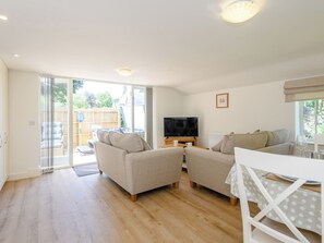 A spacious living room with a sofa set, a television, and a dining area with a table and chairs. - 1 bedroom accommodation in Fulletby, near Horncastle (Fulletby, near Horncastle)