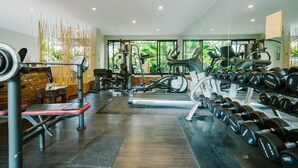 A modern gym with cardio machines, weightlifting equipment, and dumbbells. - The Opium Serviced Apartment and Hotel (Chiang Mai)