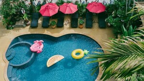 A swimming pool with lounge chairs and umbrellas, surrounded by potted plants. - The Opium Serviced Apartment and Hotel (Chiang Mai)