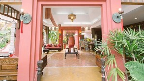A lobby with a pink archway, a central vase, and a seating area with a sofa and chairs. - The Opium Serviced Apartment and Hotel (Chiang Mai)
