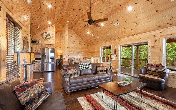 A spacious wooden cabin with a living area, kitchen, and dining space.