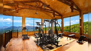 A gym with exercise equipment and large windows offering mountain views. - Shooting Star - Stunning Views, Wi-Fi, Pool Table (Sevierville)