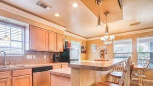 A modern kitchen with wooden cabinets, a dishwasher, a coffee maker, and a trash can. - Seas The Moment before it passes you by. (Freeport)