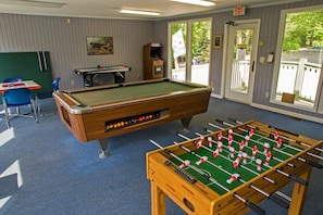 A pool table, a foosball table, and a dartboard in a room with a view of the outdoors. - Smoky Getaway - Hot tub hangs and cozy nights! (Gatlinburg)