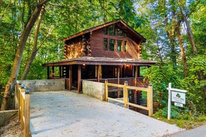 Eine Holzhütte mit Veranda, umgeben von Bäumen.