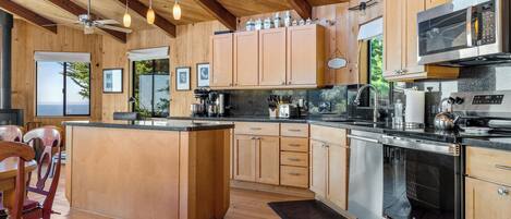 A modern kitchen with wooden cabinetry, stainless steel appliances, and a large island.