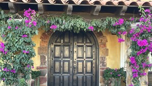 Un bâtiment traditionnel en pierre, doté d’une grande porte en bois sombre.