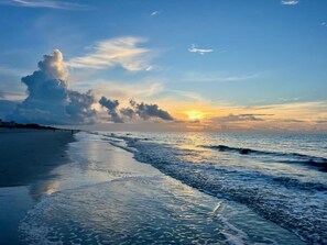 A beach with waves at sunset, a clear sky, and a distant horizon. - H.H. Beach & Tennis Resort-2/2 100% renovated ON THE BEACH condo. 5-10% DISCNTS! (Hilton Head Island)
