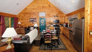 Un acogedor interior tipo cabaña con comedor, cocina y sala de estar.