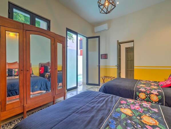 Une chambre à coucher avec un lit, une armoire et une porte donnant sur l’extérieur.