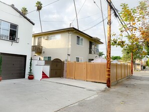 Ein zweigeschossiges Wohnhaus mit Garage, Holzzaun und kleiner Terrasse.