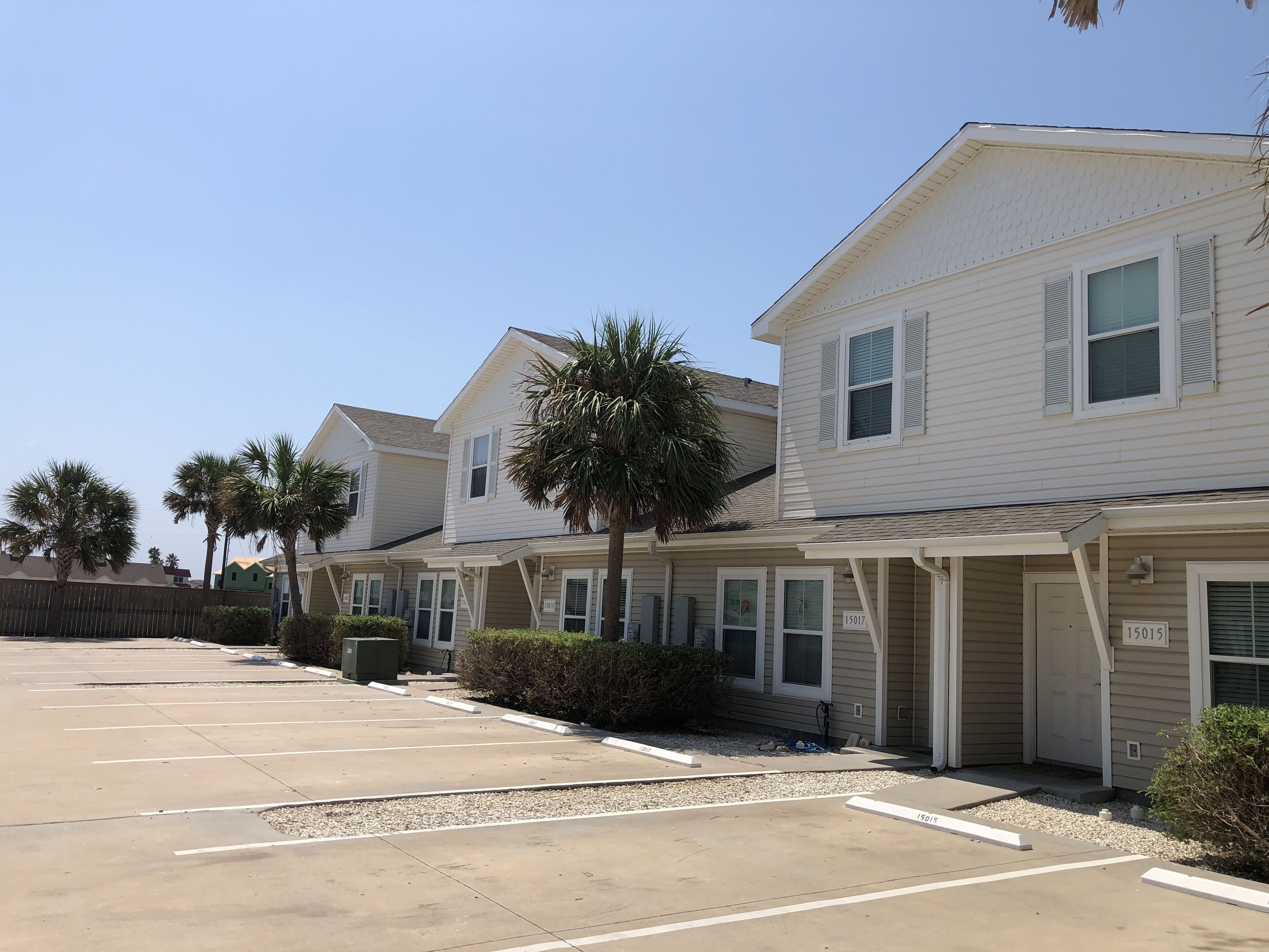 A row of two-story buildings with a parking lot in front.