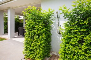 Enjoy a peaceful retreat in our serene outdoor space, surrounded by lush greenery and a covered seating area.