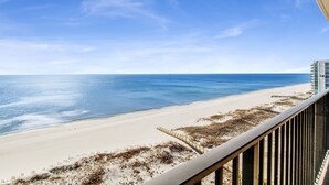 A beach view from a balcony with a railing, sandy beach, and ocean. - Beachfront 3BR @ Phoenix X • Sleeps 10 • Gulf Views • Next to Flora-Bama & Resort Amenities (Orange Beach)