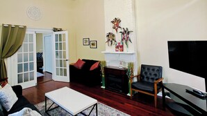 Una sala de estar con un sofá, una mesa de centro, un televisor y una chimenea.