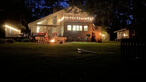 Ein modernes Haus mit Terrasse, Sitzgelegenheit im Freien und einem Feuerkorb.