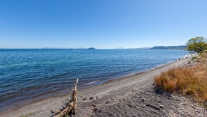 A beach with clear blue water, a sandy shore, and a distant island.
