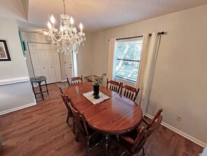 Comedor con candelabro, mesa de madera y sillas.
