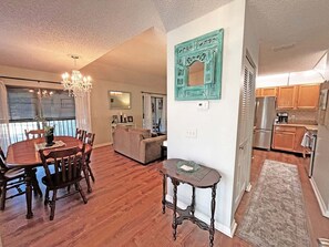 A spacious living area with a dining table, sofa, and a kitchen with modern appliances. - CQS 26 Catalonia Ct Conquistador (St. Augustine)