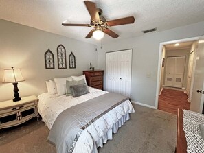 A bedroom with a bed, nightstand, dresser, and a ceiling fan. - CQS 26 Catalonia Ct Conquistador (St. Augustine)