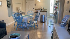 A spacious living room with a dining area, kitchen, and a small island with a sink. - Condo super close to the beach with a view of SpaceX Launch in the sky! (south padre island)