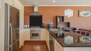 Una cocina moderna con electrodomésticos de acero inoxidable, una isla central y una salpicadera.
