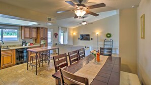 A spacious kitchen with wooden cabinets, a dining area with a table and chairs, and a ceiling fan. - Near Golf & Entertainment! Gilbert Family Getaway (Gilbert)