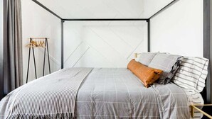 A modern bedroom with a bed, a hanging light fixture, and a view of the outside. - Bright Modern Stay | Near LAX & Stadiums I Patio (Los Angeles)
