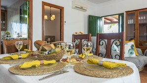 A dining table set with yellow napkins, wicker baskets, and wine glasses.