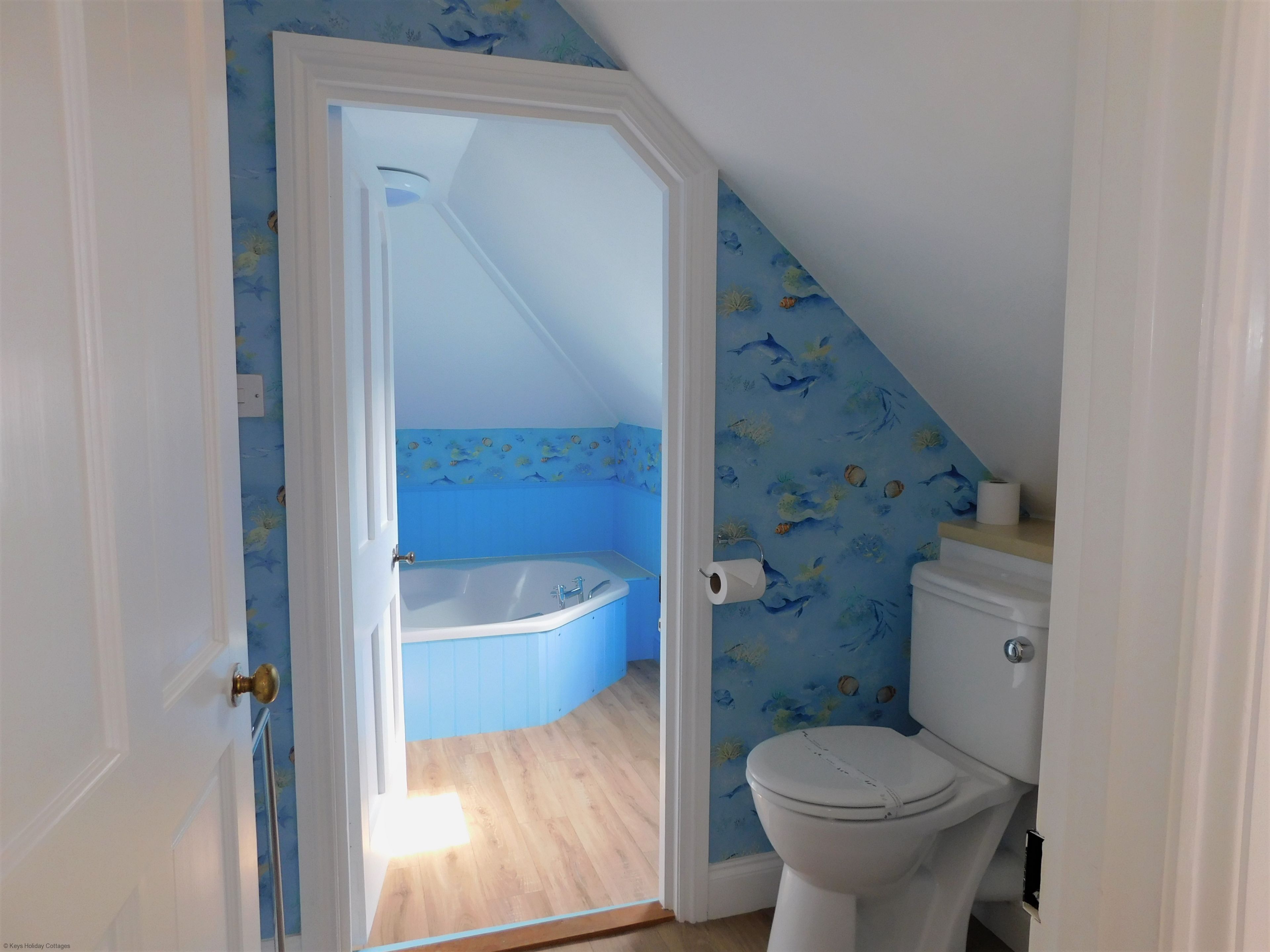 A bathroom with a toilet, a bathtub, and a shower.